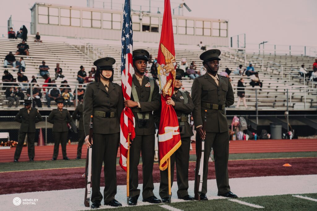 Group of four uniformed men and women raising the American flag during an outdoor event — captured by Hendley Digital, Atlanta photography portfolio.