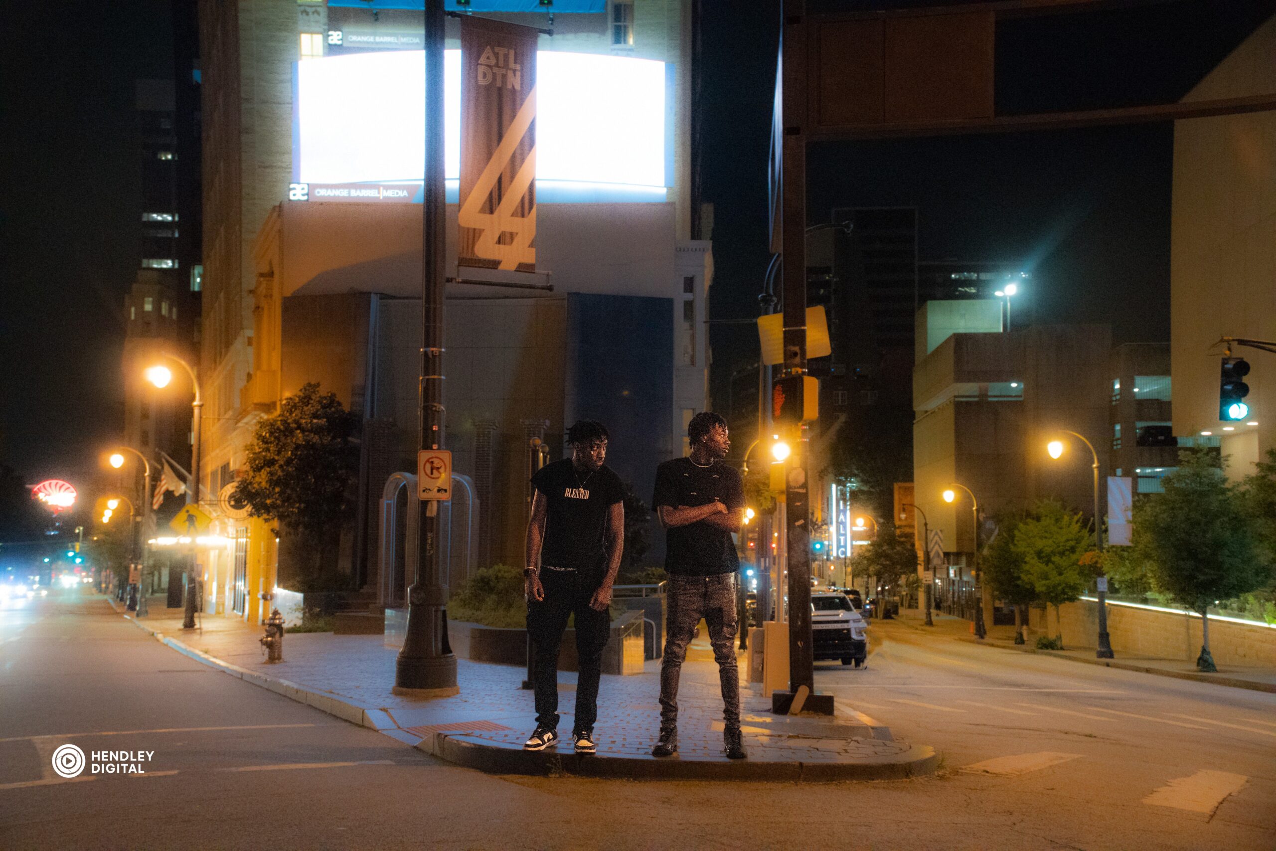 Street photography portrait of two boys posing under LED lights in Atlanta, part of the Atlanta photography portfolio by Hendley Digital.